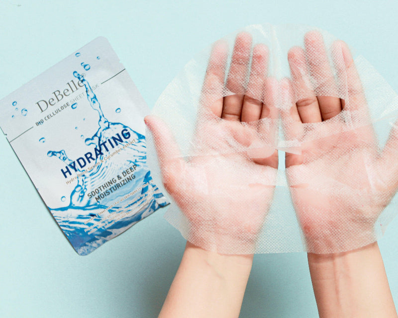 Close-in view of the hydrating sheet masks with the opened masks against blue background.