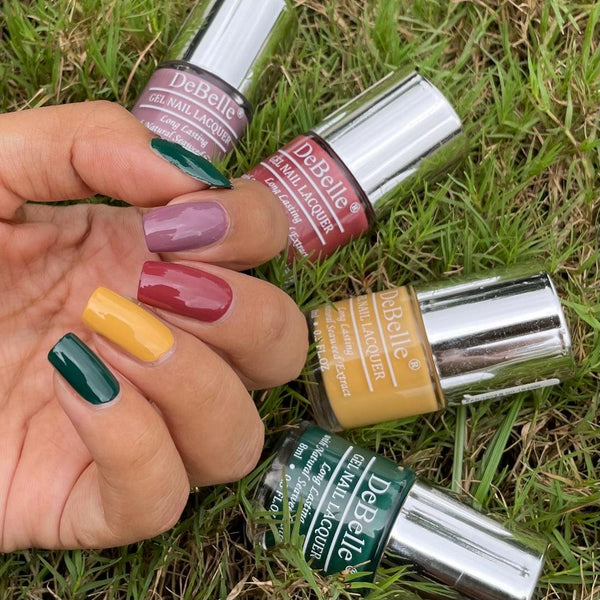 Debelle nail polish collection on ground with the nails painted