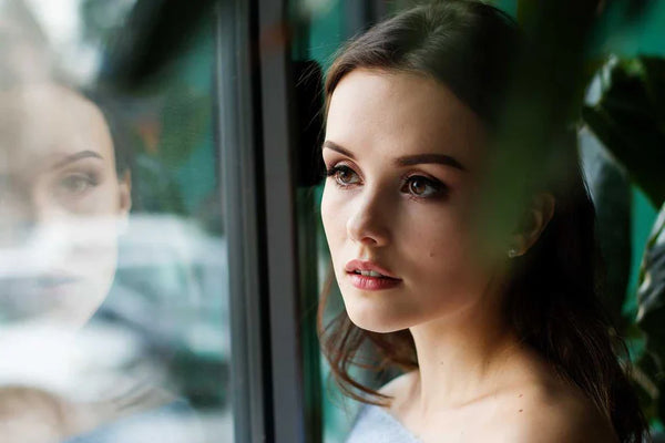 Young woman looking at the window 