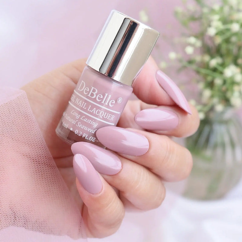 elegant light pink mauve from debelle with the beautifully manicured nails against a blurry background