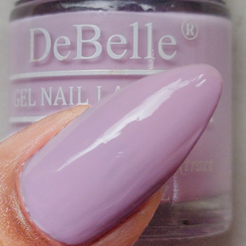 Nail painted with DeBelle Soft lilac Nail polish placed against a nail polish bottle.