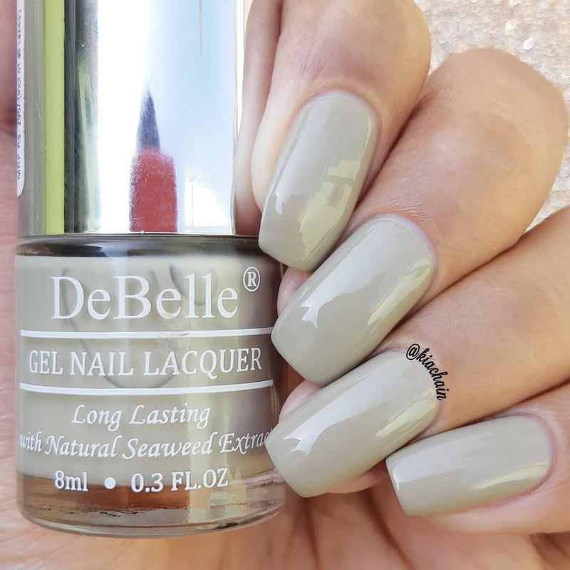 close-in view of debelle grey nail polish with the beautifully manicured nails with a blurry background