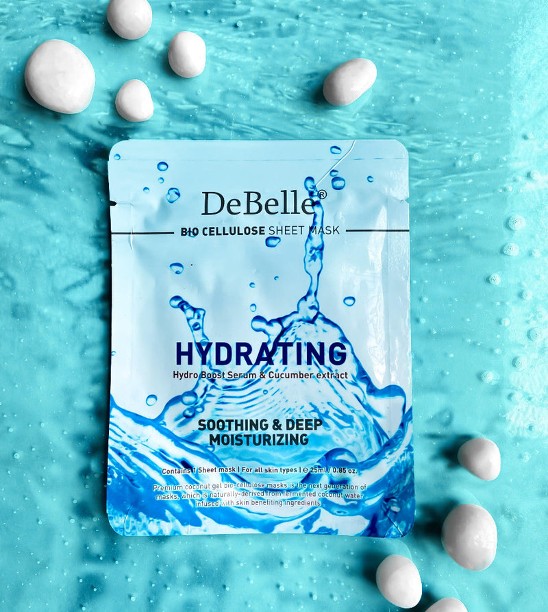 Close-up view of Debelle Hydrating sheet mask with a green leaf and a blue surface with white  stones
