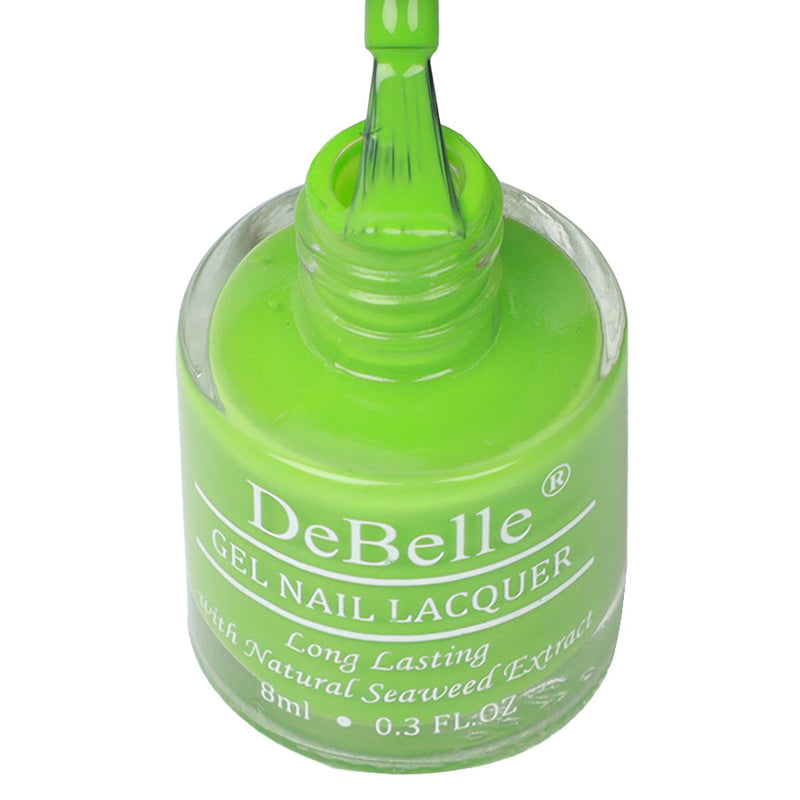 opened bottle of Debelle parrot green nail polish with a white background and a nail brush.