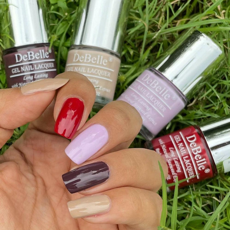 Collection of Four Nail Polish which are Victorian Beige ,Moulin Rouge, Lilac Bloom &Plum Toffee  from DeBelle with the painted Nails has Green background