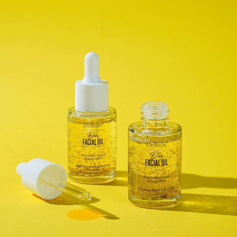 Debelle Golden Facial oil filled with oil placed against a yellow background and opened bottle next to it.