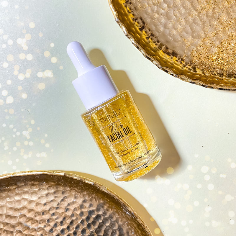 Debelle Golden Facial oil filled with oil placed against a yellow background and a brown plates next to it.