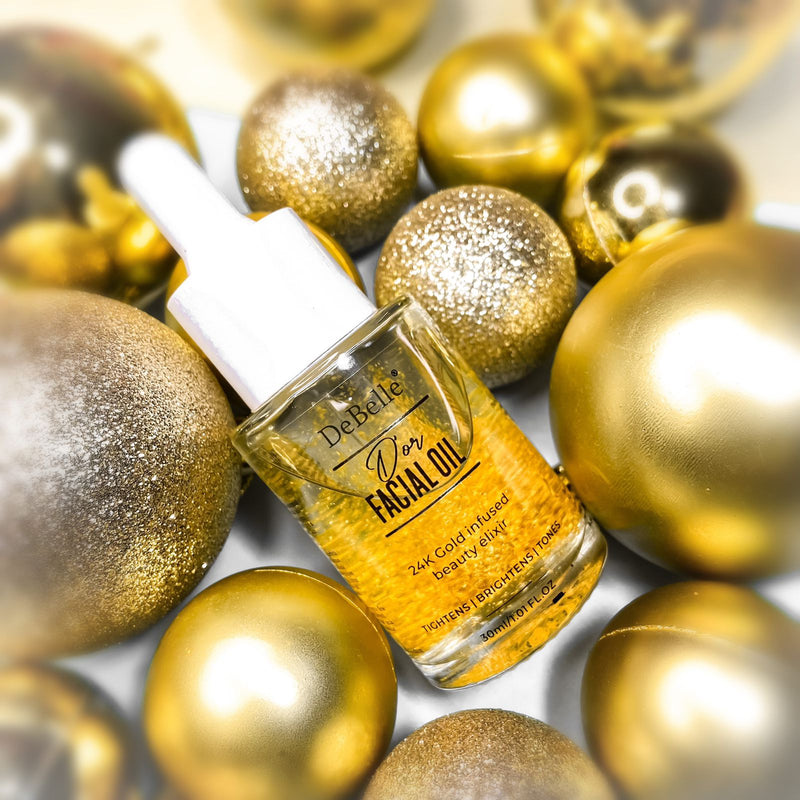 Bottle of Debelle gold facial oil placed between golden balls 