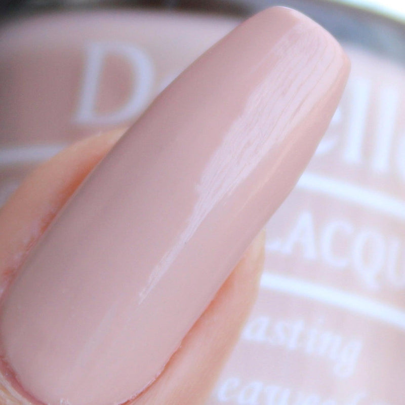 Close-in view of the painted nail with DeBelle Light pink lacquer with the blurry background.
