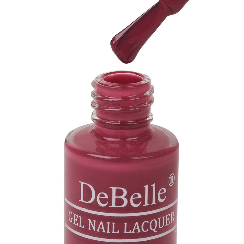 Opened bottle of Debelle Magenta Pink with the Nail Brush has White background
