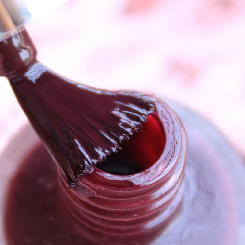 Opened bottle of Debell Deep Maroon with the Nail Brush has White background