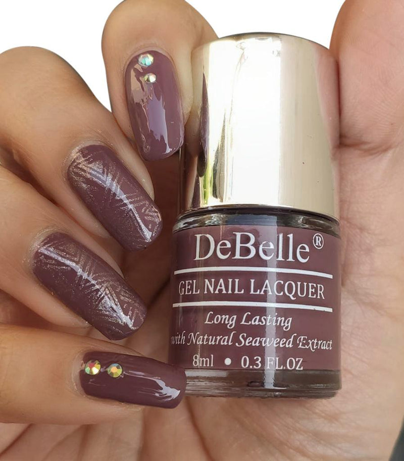 DeBelle Vintage Mauve - Close-up view of the nail polish bottle and manicured nails has white background and a nail art
