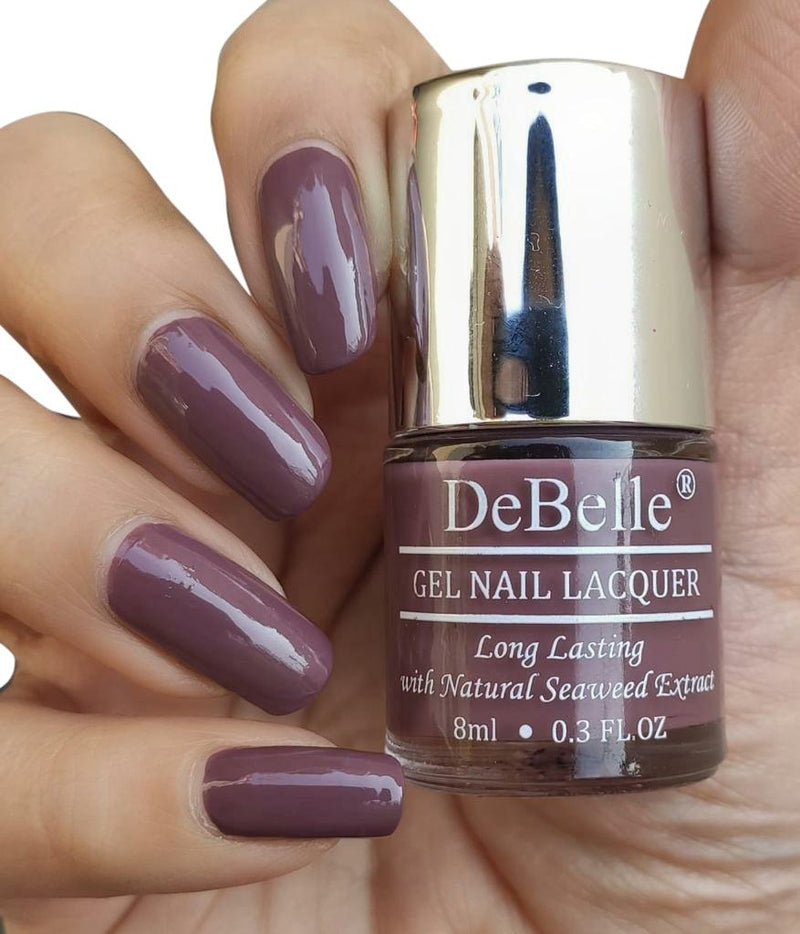 DeBelle Vintage Mauve - Close-up view of the nail polish bottle and manicured nails has white background 