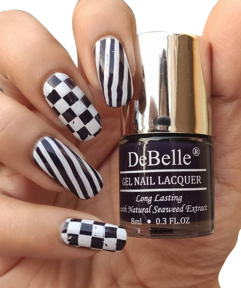DeBelle Deep Violet Nail Polish - Close-up view of the nail polish bottle and manicured nails against a white background.