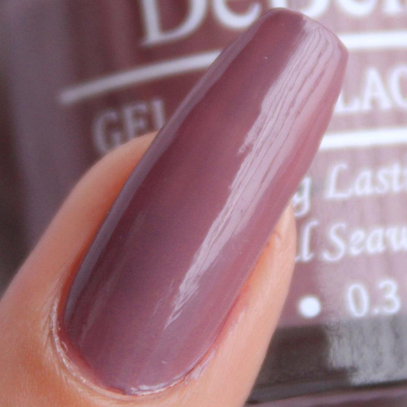 Painted nail with the muted mauve nail polish from DeBelle with nail polish bottle as a background 