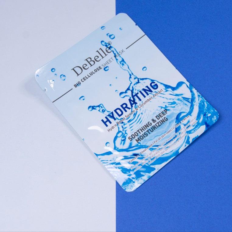 Close-up view of Debelle Hydrating sheet mask with a green leaf and a white and blue surface.