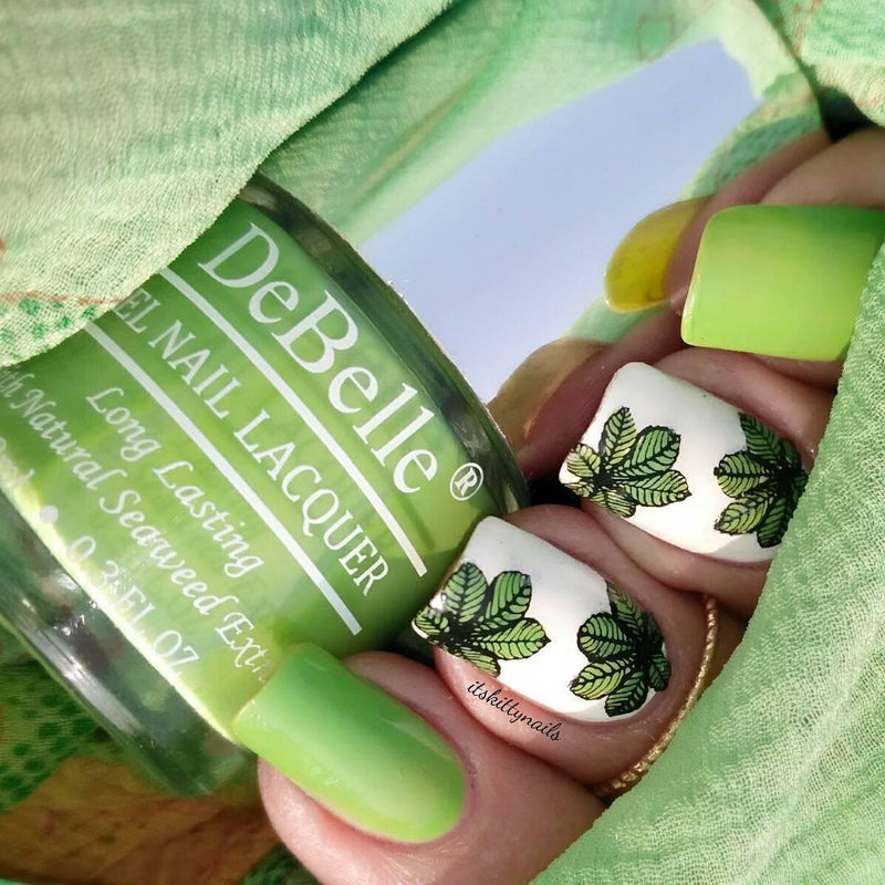 Close-in veiw of the nail manicured with Debelle Nail polish of pastel green with a nail art around a green background. 