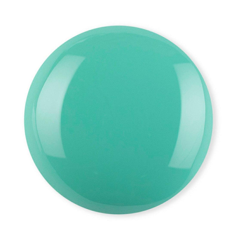 Droplet of Debelle Turquoise green nail polish against a white background.