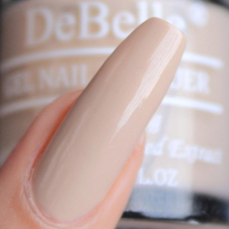close-in view of the beautifully manicured nails with Debelle Beige nail polish with a blurry background.